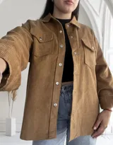 Sobrecamisa color camel de pana con cuello camisero, cierre frontal con botones metálicos a presión, dos bolsillos con solapa abotonada en el pecho y mangas largas con puños abotonados.