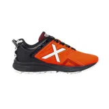 Championes deportivos Munich modelo Stroke 04, diseñados para hockey, con combinación de colores naranja y negro. Presentan el logo característico de la marca en blanco en el lateral, suela con relieve para mayor tracción y cordones negros.