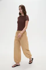 Babucha tostada de tiro alto con cintura elástica y cordón ajustable del mismo tono. Presenta diseño amplio con botamangas fruncidas mediante elástico.