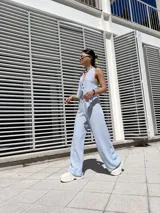 Pantalón celeste a rayas verticales blancas, de corte palazzo y cintura alta con elástico.