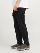 Jean negro de tiro alto, corte tapered, cinco bolsillos y cierre con botón.