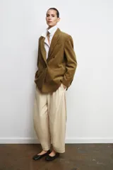 Blazer oversize de pana con cuello solapa y manga larga. Presenta cierre frontal cruzado con botones, bolsillos delanteros y forro interior a tono.