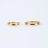 Par de alianzas bombé en oro 18k de diseño clásico, con acabado pulido y una de ellas engastada con un pequeño diamante central.