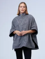 Poncho de tejido soft con estampado de cuadros, cuello alto y cierre frontal parcial. Presenta diseño holgado con mangas amplias y bolsillos laterales.