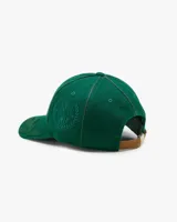Gorra verde botella de estilo varsity, estructurada, con la inscripción frontal "NUDE Project" bordada en blanco. Presenta detalles de hojas bordadas en tono sobre tono sobre la visera.