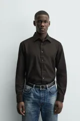 Camisa de corte regular fit en color bordó, con cuello italiano, manga larga con puños abotonados y cierre frontal de botones.