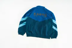 Campera deportiva unisex azul con paneles diagonales en contraste celeste y blanco. Incluye micrográfico Kaboa en el frente y gráfico en la espalda.