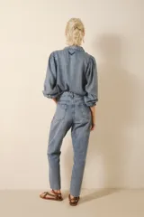 Jean de corte mom fit, tiro medio-alto y calce holgado, con pierna recta que ajusta hacia el ruedo. Confeccionado en denim azul con un lavado claro, localizado, con bigotes. En los bolsillos traseros lleva un bordado de alas.