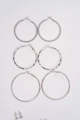 Set de caravanas compuesto por tres pares de argollas de diferentes texturas y tres pares de caravanas pequeñas tipo broquel con detalles de cristales.