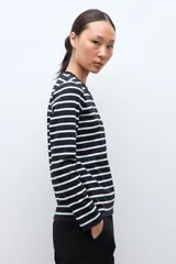 Remera de manga larga con diseño de rayas horizontales en blanco y negro, cuello redondo y corte clásico.