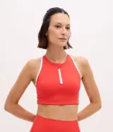 Top deportivo Get Over de microfibra color rojo con cuello halter, cierre frontal y detalles de bies en color blanco. Incluye copas para mayor soporte.