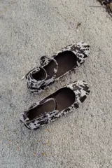 Balerinas con estampado animal print, doble tira con hebillas metalizadas y detalles de tachas en frente y talón.