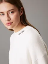 Sweater blanco de punto con cuello redondo y logo de Calvin Klein bordado en el cuello.
