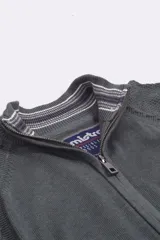 Campera tejida de punto con cierre frontal completo, cuello alto y detalles de rayas en el interior del cuello. Confeccionada en algodón, presenta un diseño clásico y versátil.