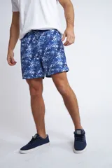 Short de baño con cintura elástica y cordón ajustable, confeccionado en tela ligera de secado rápido. Presenta un estampado botánico integral en tonos amarillos, blancos y azules, con dos bolsillos delanteros y uno posterior.