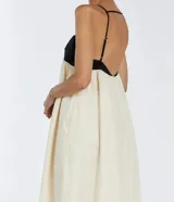 Vestido largo de tirantes finos, con corpiño negro y falda blanca.