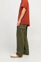 Pantalón cargo de corte amplio y pierna ancha, color verde oliva. Presenta bolsillos laterales tipo cargo, bolsillos delanteros y traseros, con cierre de cremallera y tejido de sarga resistente.