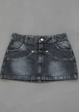 Minifalda de jean rígido color negro con efecto lavado acid wash, tiro bajo y diseño de bolsillos delanteros superpuestos con detalles de tachas metálicas.