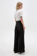 Pantalón jean de tiro alto y corte ancho tipo wide leg, con bolsillos y cierre frontal.