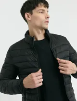 Campera 2 en 1 color beige, con cuerpo y capucha desmontable, manga larga, cierre frontal con botones a presión y bolsillos laterales engomados.