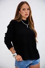 Sweater de punto acanalado en color negro, con cuello redondo y mangas largas. Presenta un diseño de corte recto y textura acanalada vertical.