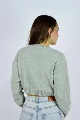 Buzo corto de tejido chenille color beige, con cuello redondo y puños y dobladillo acanalados.