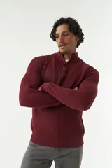 Sweater gris de punto con cuello alto y medio cierre con cremallera.