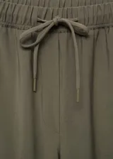 Pantalon de corte recto y estilo jogger, confeccionado en tejido fluido color verde militar. Presenta cintura elástica con cordón ajustable y bolsillos laterales.