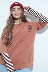 Remera oversize de manga corta con efecto gastado, color terracota, con estampa gráfica retro en el pecho.