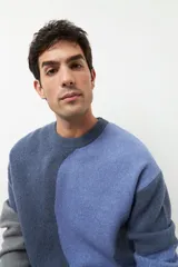 Sweater de punto con diseño geométrico en tres tonos de azul y gris, de cuello redondo y manga larga.