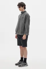 Buzo gris con cuello alto y cierre parcial.