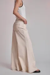 Pantalón de jean color crudo, corte palazzo con godets y costuras a contratono.