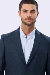 Saco sport de lana en color gris oscuro, con diseño clásico de solapa tradicional, cierre frontal de dos botones y bolsillos laterales con solapa.