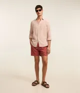 Bermuda masculina de corte recto, color rojo, con cintura elástica y cordón de ajuste. Cuenta con bolsillos laterales y traseros, confeccionada en una mezcla de algodón y lino.