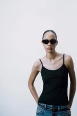 Camiseta ajustada negra con escote redondo y tirantes finos.