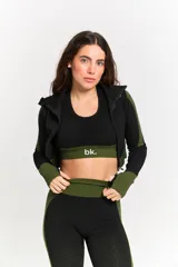 Conjunto deportivo de tres piezas compuesto por top, calza chupín y campera con cierre. Presenta un diseño texturizado en color negro con detalles en verde limón en los laterales y elásticos.