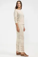 Falda midi color crema, tejida a crochet con aberturas en la parte inferior.