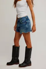 Short de denim de tiro medio y calce relajado, con cierre de cremallera y botón, cinco bolsillos, y detalles de desgastes y deshilachados.