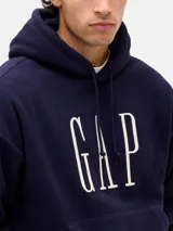 Canguro de polar rojo con capucha y cordones ajustables. Presenta el logo de la marca estampado en blanco en el centro del pecho y un bolsillo frontal tipo canguro.