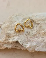 Aros de diseño minimalista en forma de corazón irregular, con acabado metálico pulido y cierre de perno con mariposa.