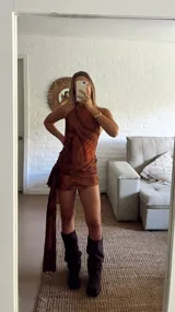 Vestido corto de microtul con diseño de doble capa y estampado abstracto en tonos marrones. Presenta escote halter y un detalle de frunce lateral con una tira larga colgante.