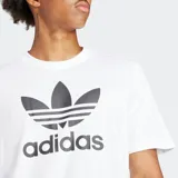 Remera blanca de algodón con cuello redondo y logo Adidas Trifolio estampado en el pecho.