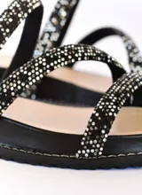 Sandalia de cuero negro con tiras cruzadas decoradas con strass brillante. Cuenta con una base de plataforma baja de 3,5 cm y plantilla acolchada.