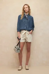 Short color crema de algodón con cuatro bolsillos y lazo decorativo en la cintura.