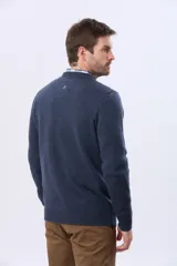 Buzo tejido de lana con escote redondo a la base y mangas largas. Presenta puños y ruedo acanalados, con un pequeño logo bordado en el pecho.