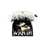 Camiseta Vampstr color blanco con corte boxy, cuello redondo y mangas cortas. Presenta un gran estampado frontal con el rostro sombrío de una persona y las inscripciones "SAINT 93" y "WRATH" en estilo grafiti con detalles de brillos.