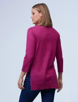 Buzo tejido de hilado fino color fucsia, marca Cable & Gauge. Cuello con solapa, escote en V con aplique de botones metálicos. Manga larga amplia con puño elastizado y laterales con tajo.