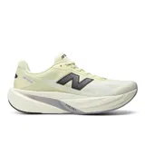 Championes de running New Balance FuelCell Rebel v5, color amarillo claro con detalles en negro y gris. Presentan capellada de malla transpirable, entresuela alta FuelCell con tecnología PEBA y EVA, y el logo característico 'N' en el lateral.