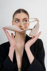 Zapato de tacón bajo color negro, con punta en V, tiras cruzadas en el empeine y cierre de hebilla en el tobillo. El tacón es ancho y mide 5 cm.