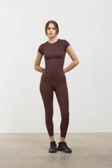Remera tipo baby tee color marrón espresso, de corte ajustado al cuerpo, con escote redondo y mangas cortas. Confeccionada en tejido ultra liviano y suave con compresión media.